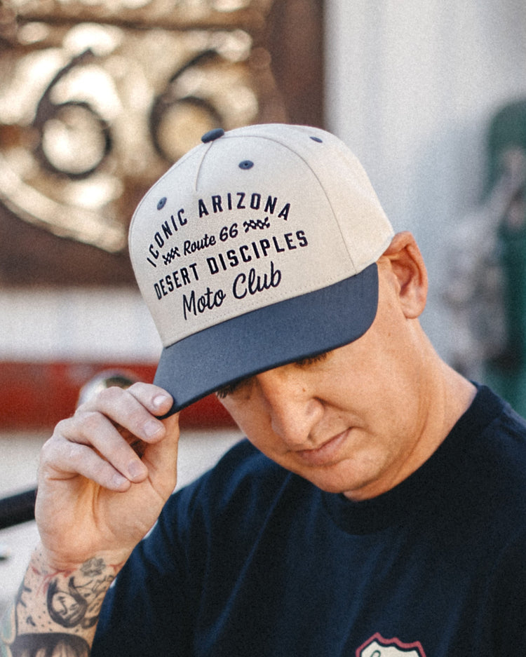 Man tipping the cream and navy Route 66 Desert Disciples Moto Club Two Tone Hat